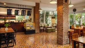 A restaurant with brick pillars, a tiled floor, and a bar area with shelves of bottles. - Skyline Boutique Hotel (Phnom Penh)