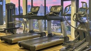 A gym with treadmills, a weight machine, and a stationary bike. - Skyline Boutique Hotel (Phnom Penh)