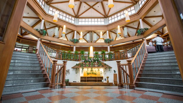 A spacious atrium with a high ceiling, multiple staircases, and a central seating area with a plant arrangement. - Maneechan Resort & Sport Club (Chanthaburi)