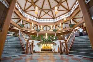 A spacious atrium with a high ceiling, multiple staircases, and a central seating area with a plant arrangement. - Maneechan Resort & Sport Club (Chanthaburi)