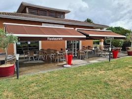 Un restaurante con terraza y porche cubierto.