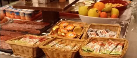 A buffet with various food items and baskets of snacks.