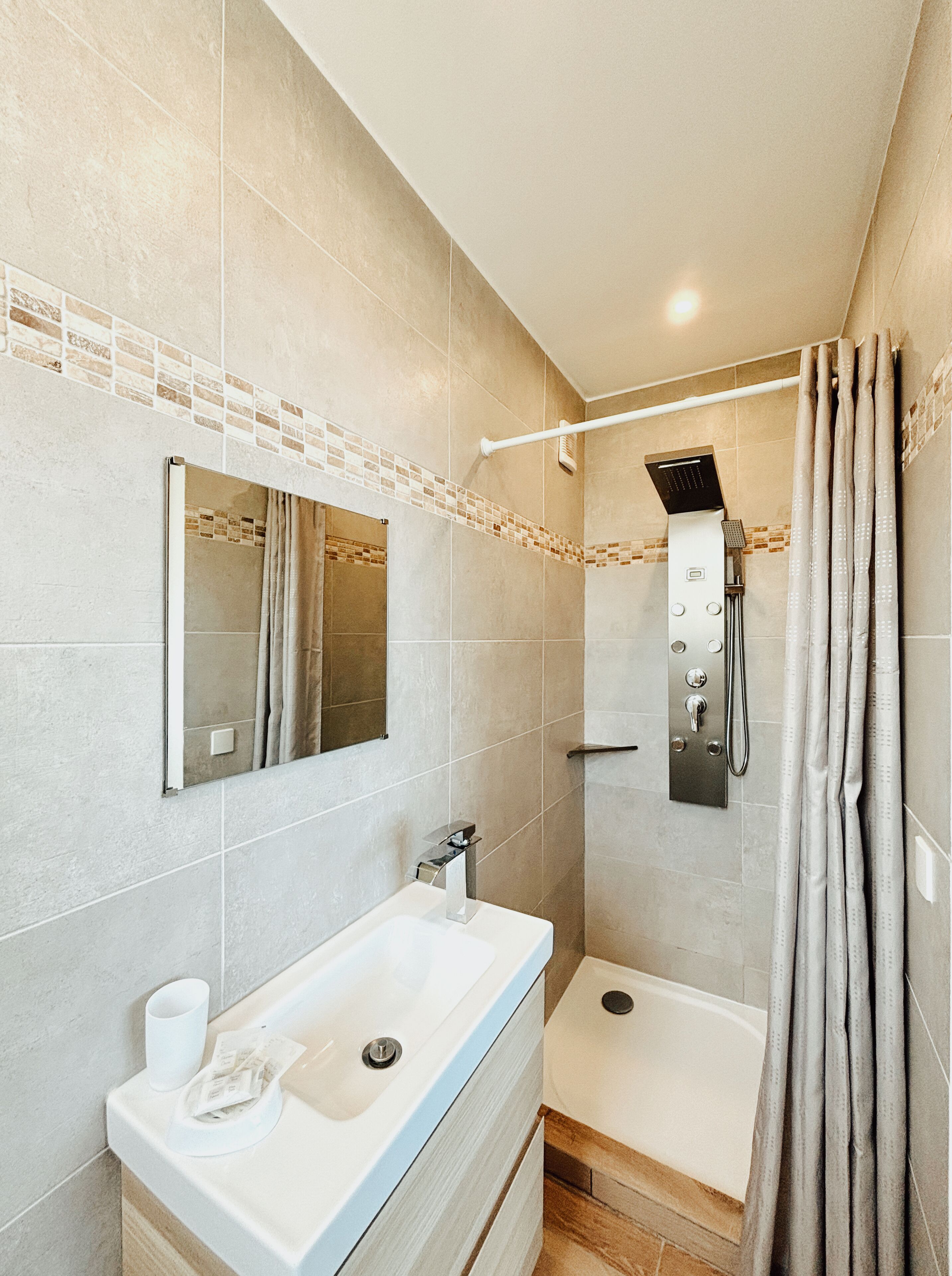 Un baño moderno con un lavamanos grande, espejo, ducha y bañera.