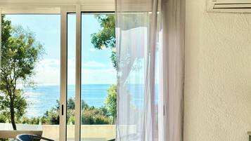 A dining area with a table, chairs, and a view of the sea.