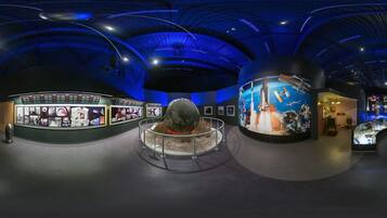 Um museu com uma exposição central esférica, rodeada por painéis informativos.