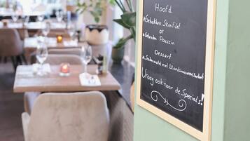 A chalkboard menu in a restaurant with a price of €37.50.