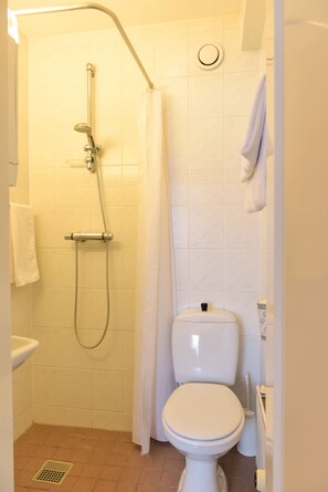 A small, clean bathroom with a shower, toilet, and sink. - Hotel Noordzee (Katwijk Aan Zee)