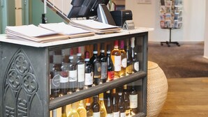 A bar area with a cash register, a computer, and a wine display. - Hotel Noordzee (Katwijk Aan Zee)