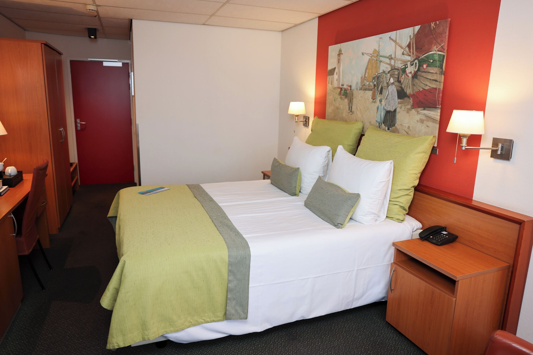 A hotel room with a bed, bedside tables, a desk, and a painting on the wall.