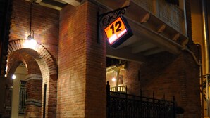 A brick building with a balcony and a sign indicating room number 12. - No12 Boutique Hotel (Tbilisi)
