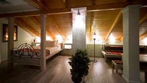 A cozy attic bedroom with a wooden ceiling, a bed, a bench, and a potted plant. - No12 Boutique Hotel (Tbilisi)