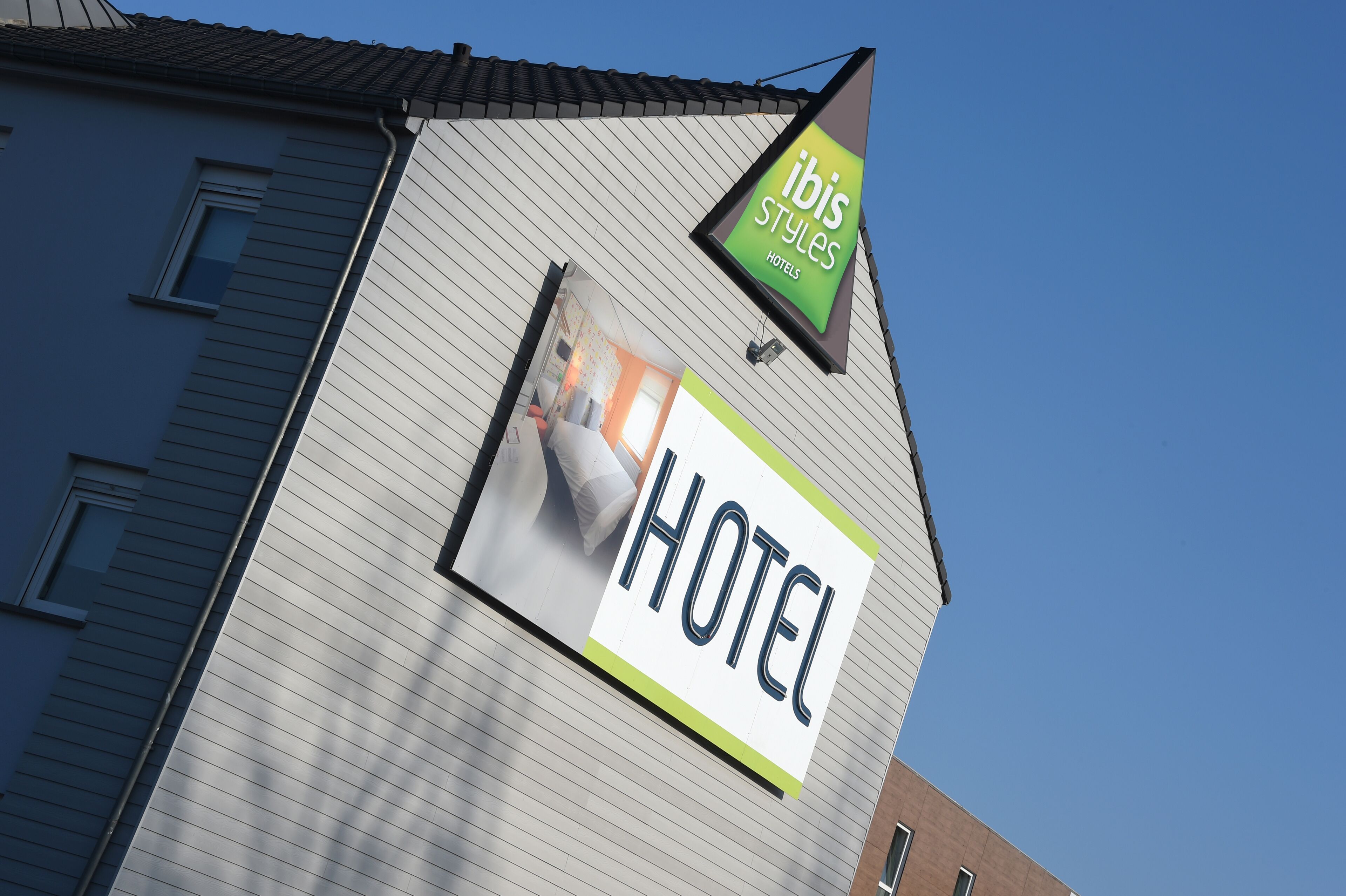Un letrero de hotel con el nombre 'ibis Styles Hotels' y un rótulo grande que dice 'HOTEL'.