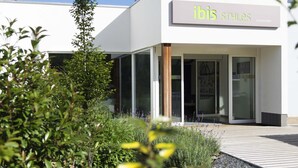 Un bâtiment moderne avec une enseigne indiquant « ibis styles La Louvière ».