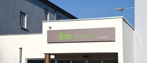 Un edificio con un cartel que dice 'ibis styles La Louviere'.