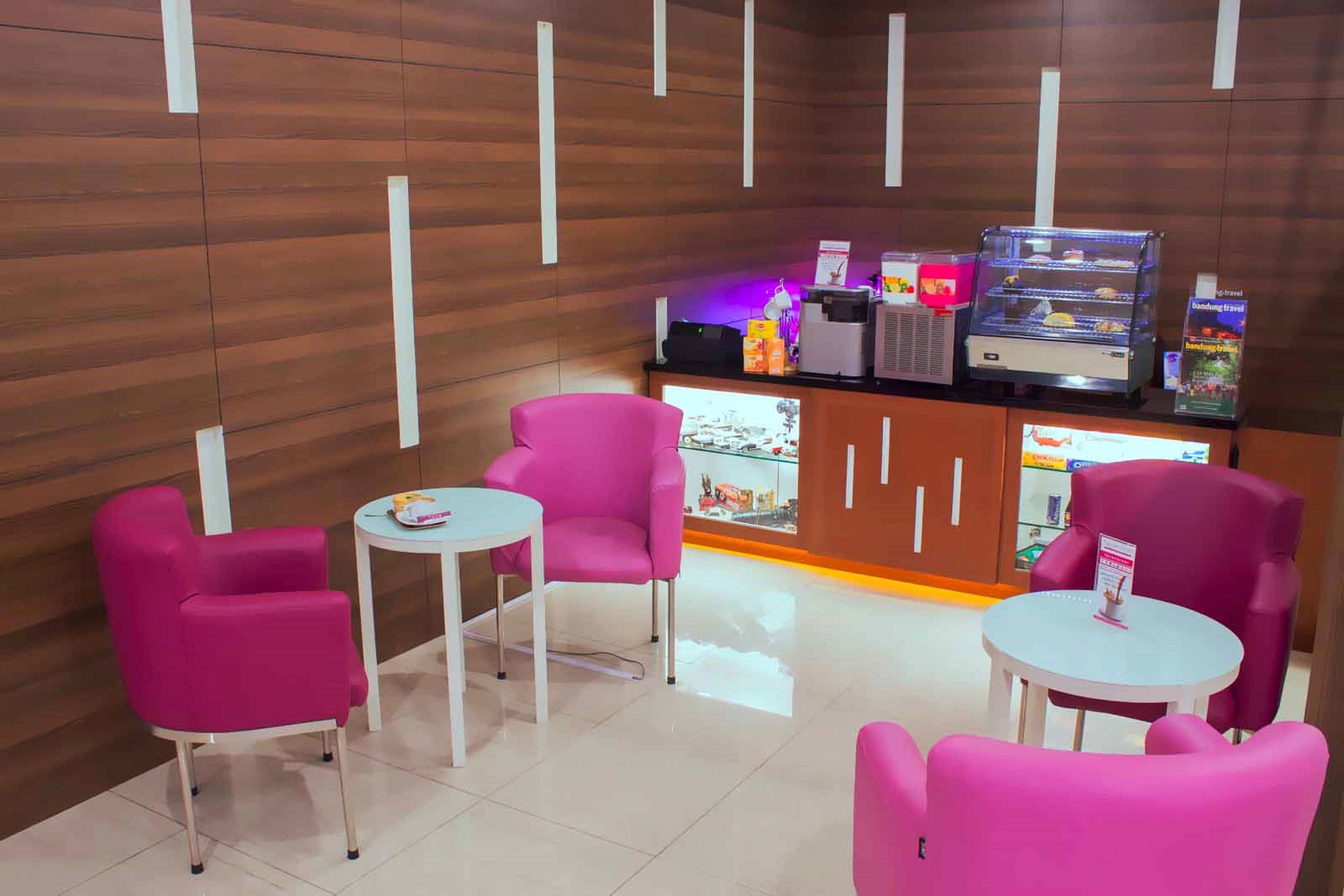 A modern lounge area with wooden paneling, a coffee machine, and a display case.