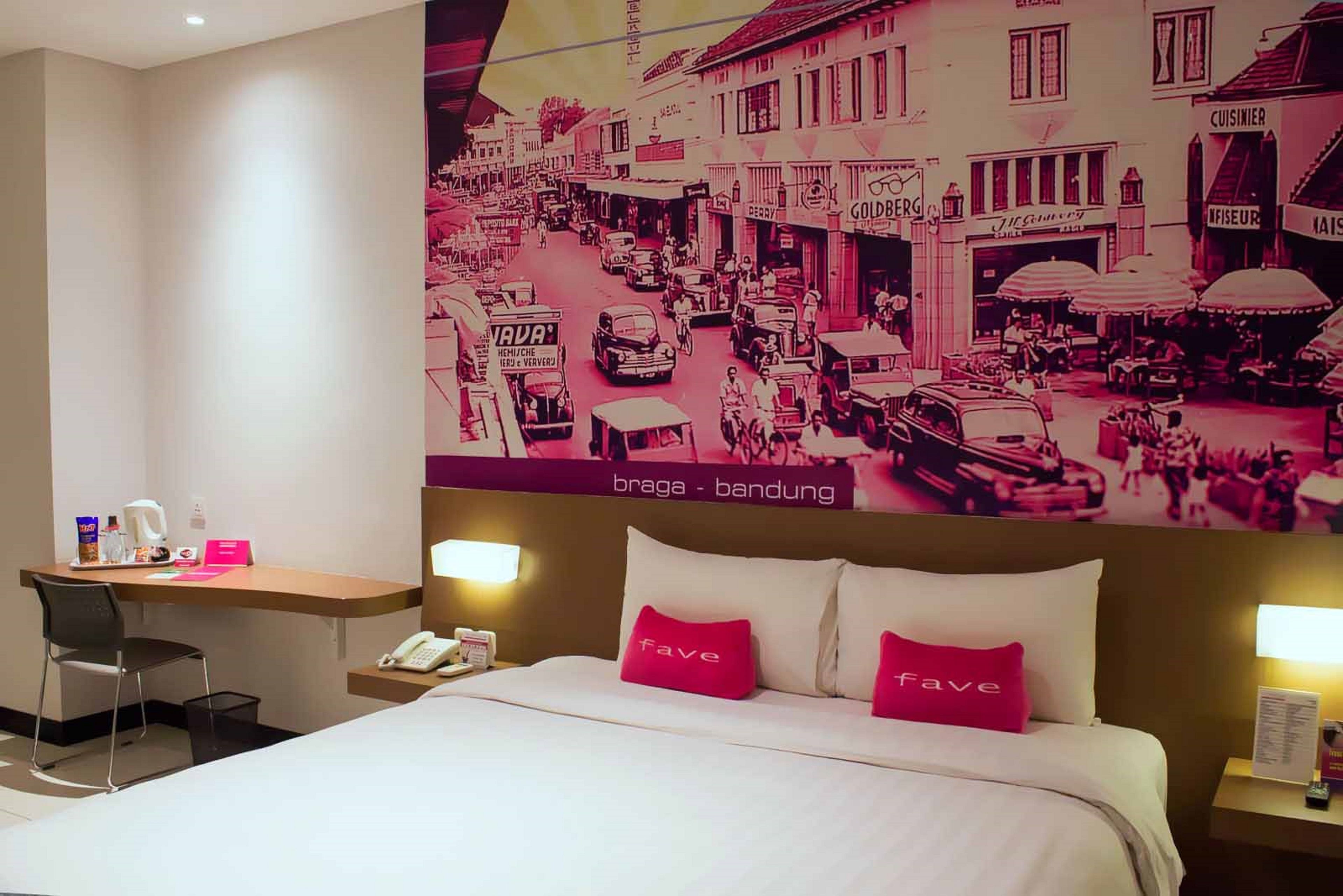 A hotel room with a bed, two bedside tables, a desk, and a chair.