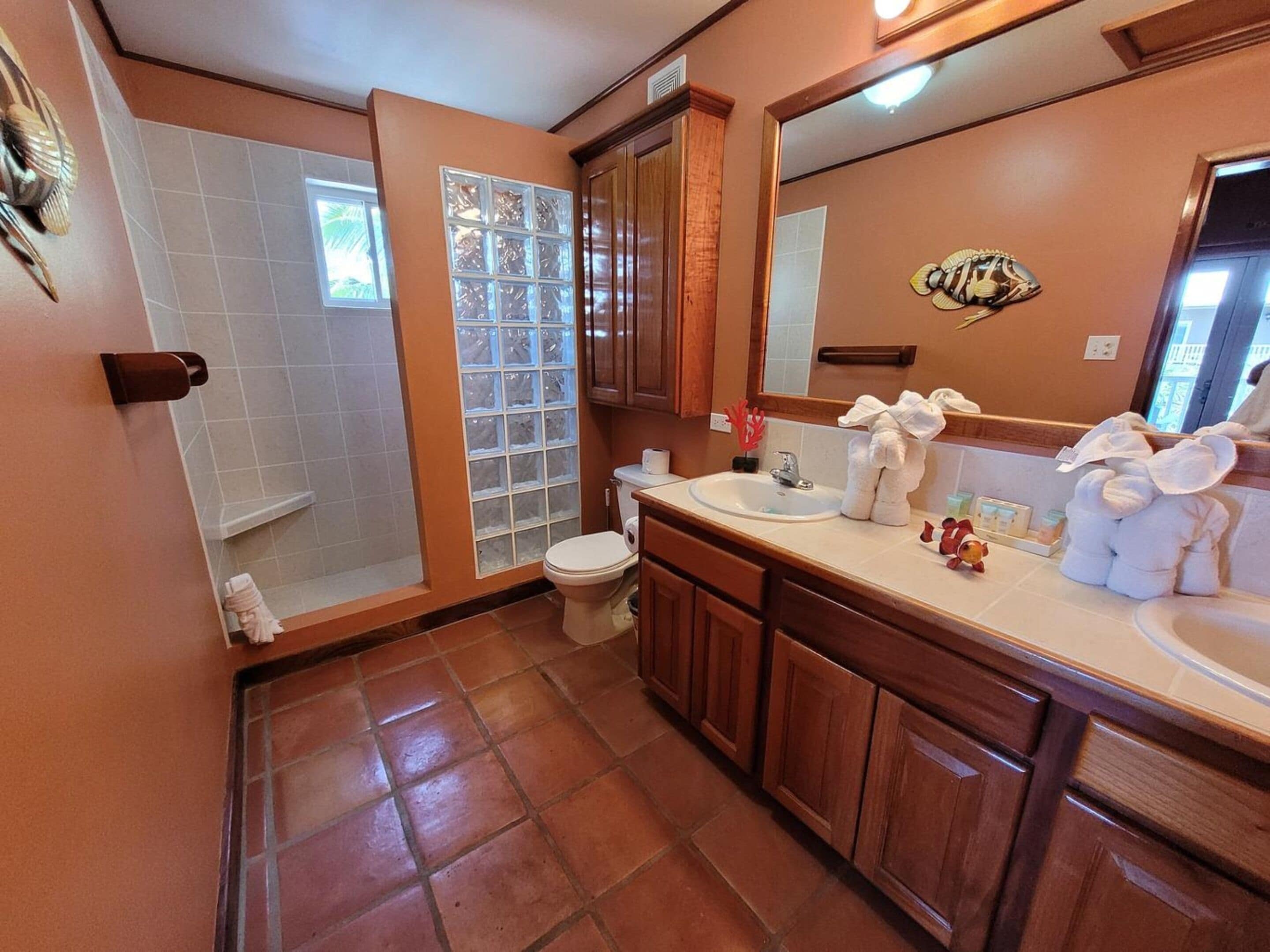 Een badkamer met douche, toilet en wastafel.
