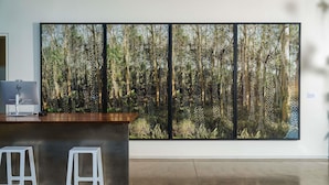 A modern interior with a large window, a desk, and two white stools. - 21c Museum Hotel Bentonville (Bentonville)