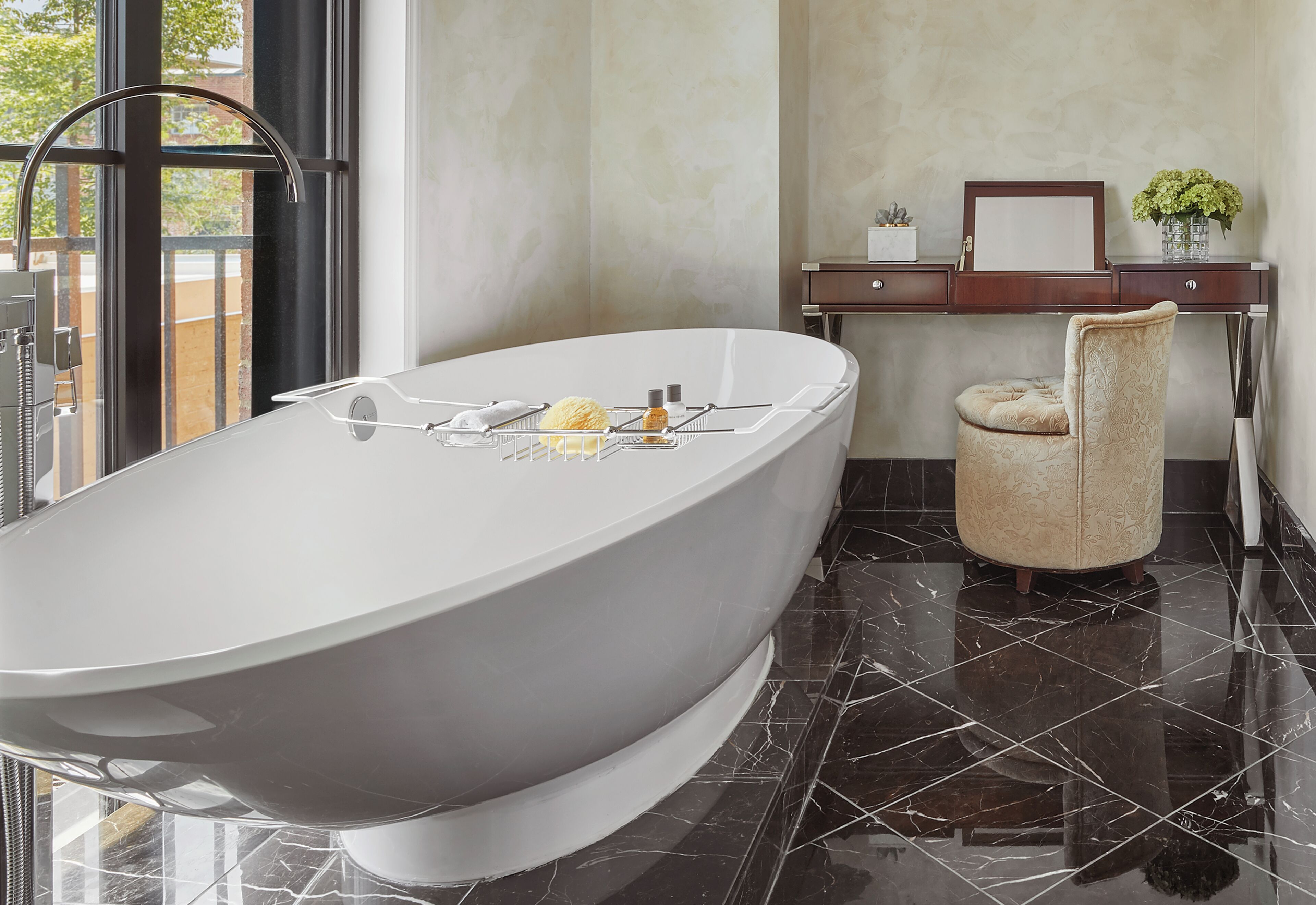 Un bagno moderno con una vasca da bagno freestanding, un vanità con uno specchio e una sedia.