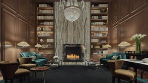 Ein luxuriöses Wohnzimmer mit Kamin, Bücherregalen und bequemen Sitzgelegenheiten.