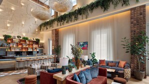 A modern lounge area with a bar, seating, and decorative plants.