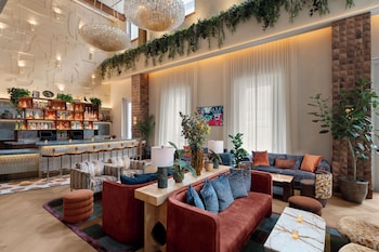 A hotel lobby with a reception desk, seating area, and a large plant wall. at Hyatt Union Square New York