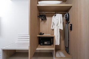 Ein begehbarer Kleiderschrank mit Holzregalen, einer Kleiderstange und einem Schuhregal.