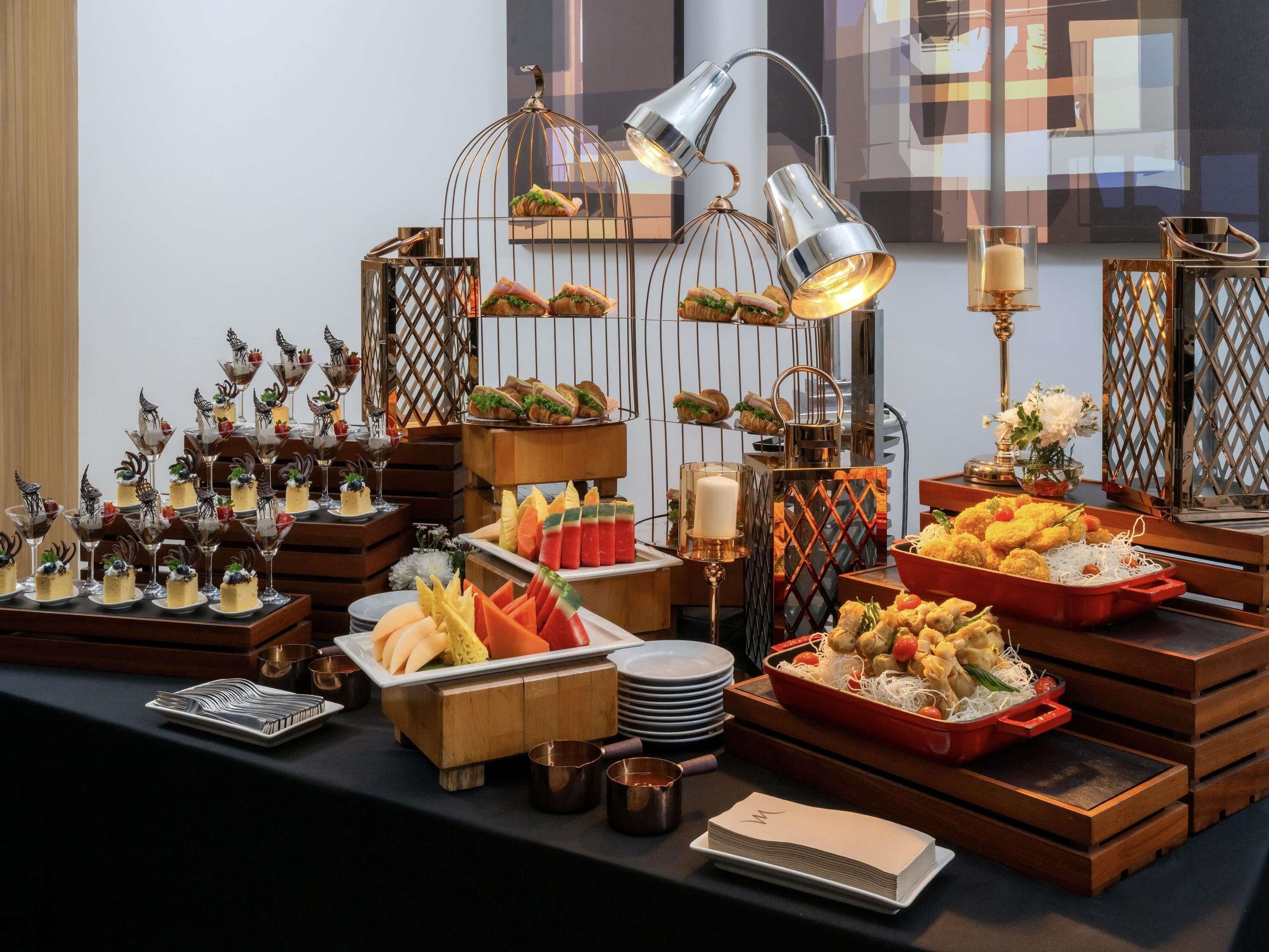 A buffet setup with various food items, decorative elements, and lighting fixtures.