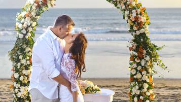 Couples can exchange vows on a picturesque beach with the ocean as a serene backdrop.