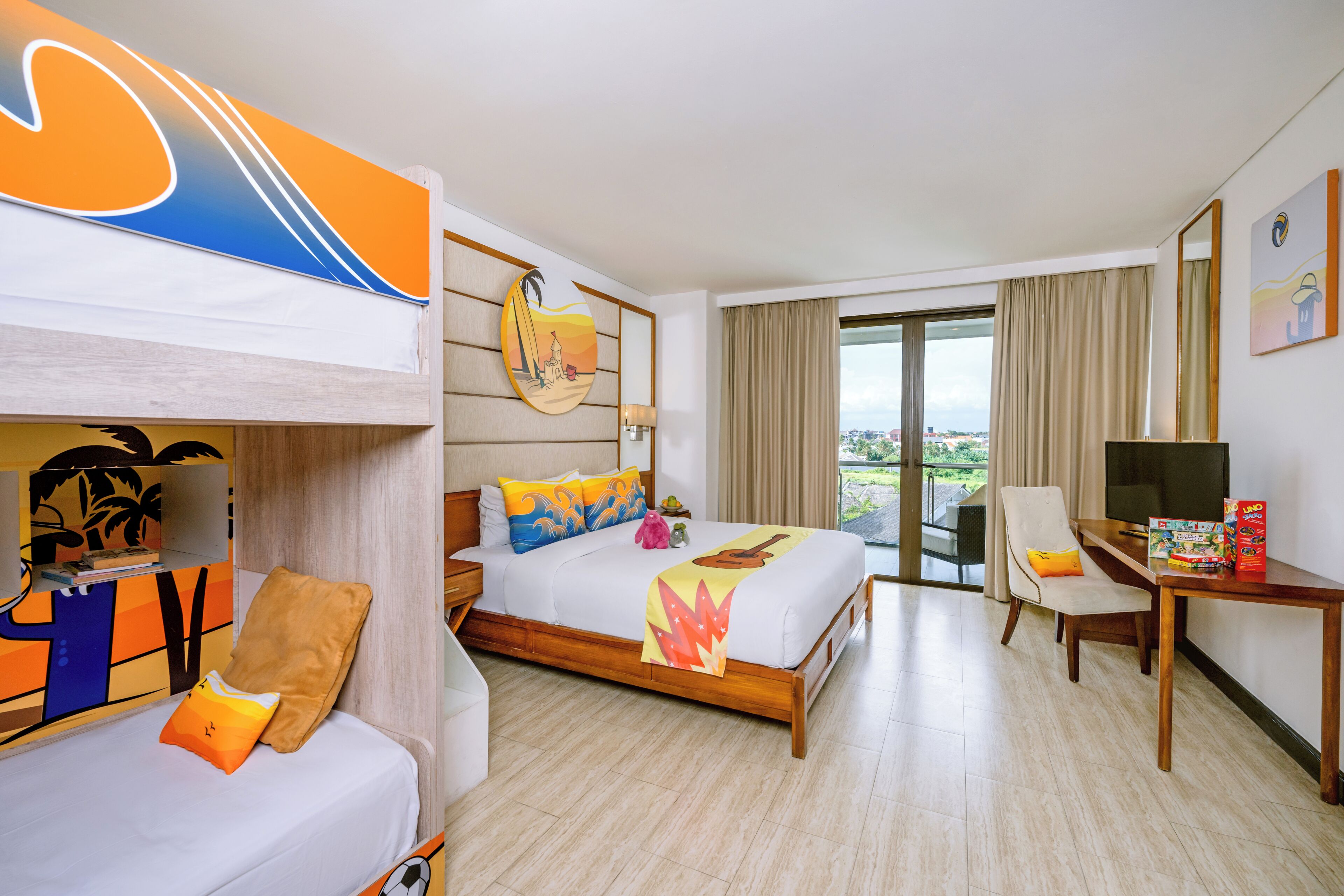 A hotel room with a bunk bed, a desk with a chair, a television, and a large window with a view.