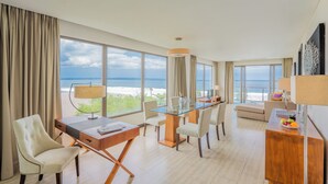 Ett hotellrum med en matplats, ett skrivbord och utsikt över havet.