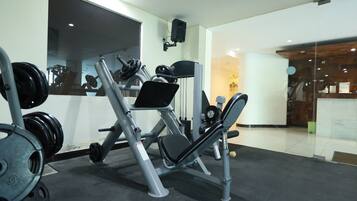 A gym with exercise equipment, a mirror, and a speaker.