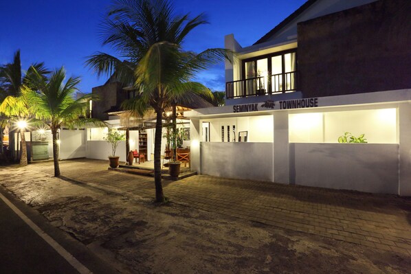 A well-lit, modern townhouse with a balcony and a covered outdoor seating area. - Seminyak Townhouse Apartment (Legian)
