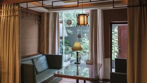 Una habitación moderna con una mesa de vidrio, un sofá y un farol colgante.