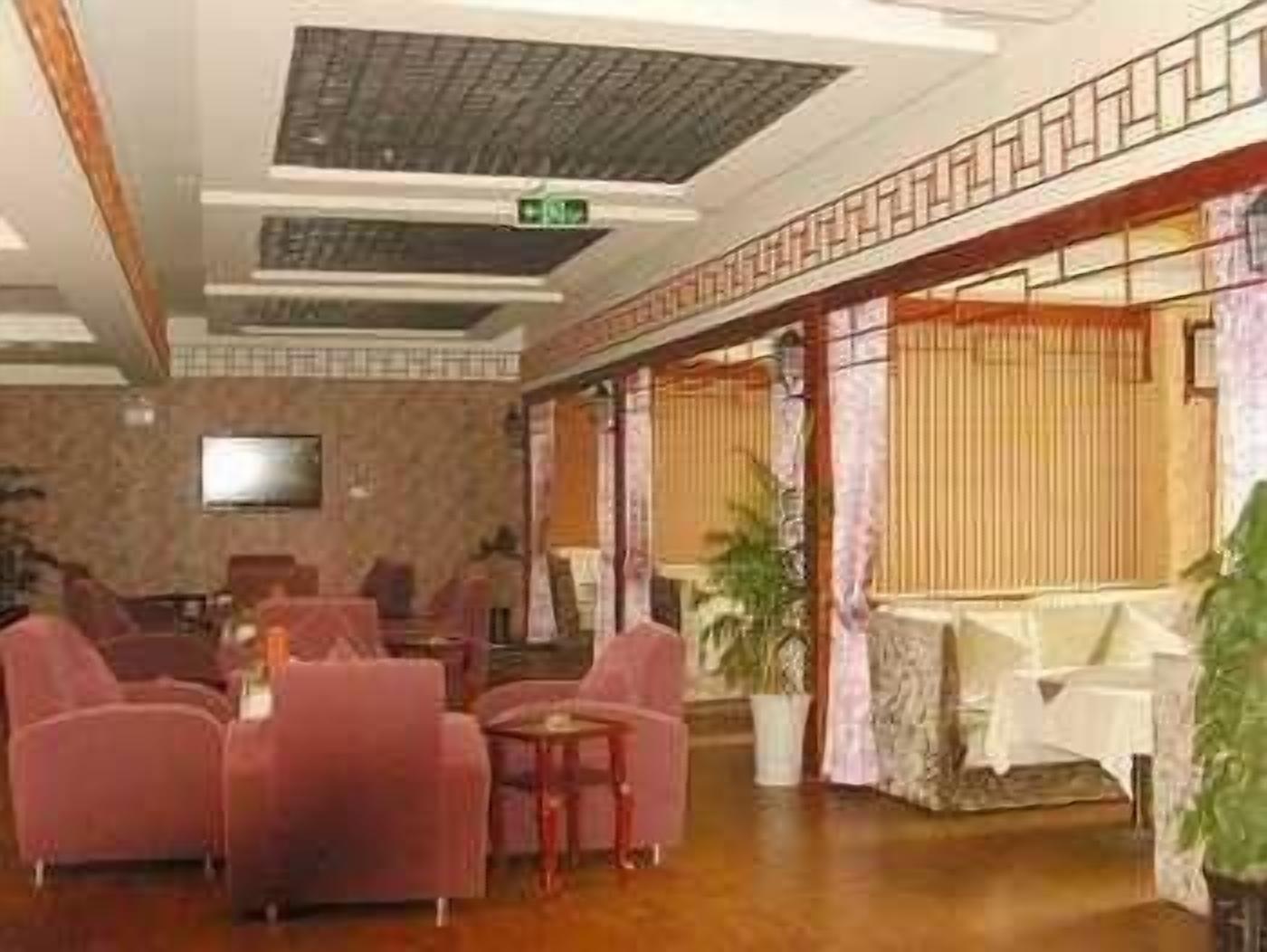 A lobby with a seating area, a television, and a staircase.
