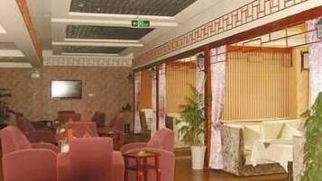 A lobby with a seating area, a television, and a staircase.