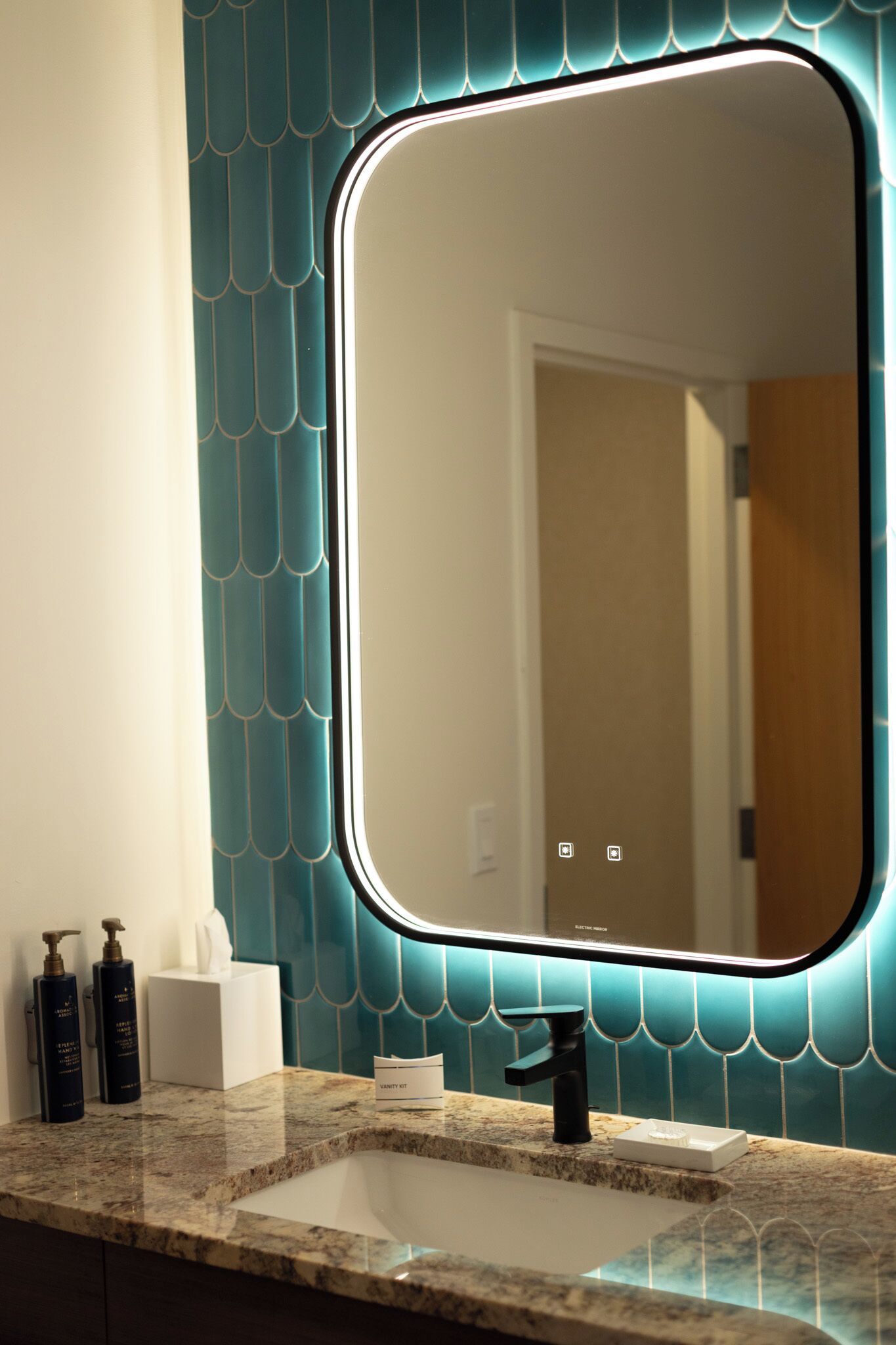 Une salle de bain équipée d’un lavabo, d’un miroir et d’articles de toilette.