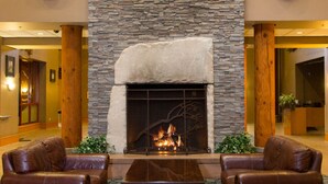 A lobby with a stone fireplace, leather chairs, and a patterned carpet. - Little Creek Casino Resort (Shelton)