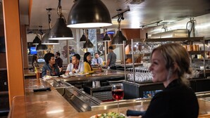 A restaurant interior with a bar area, dining tables, and hanging pendant lights. - Little Creek Casino Resort (Shelton)