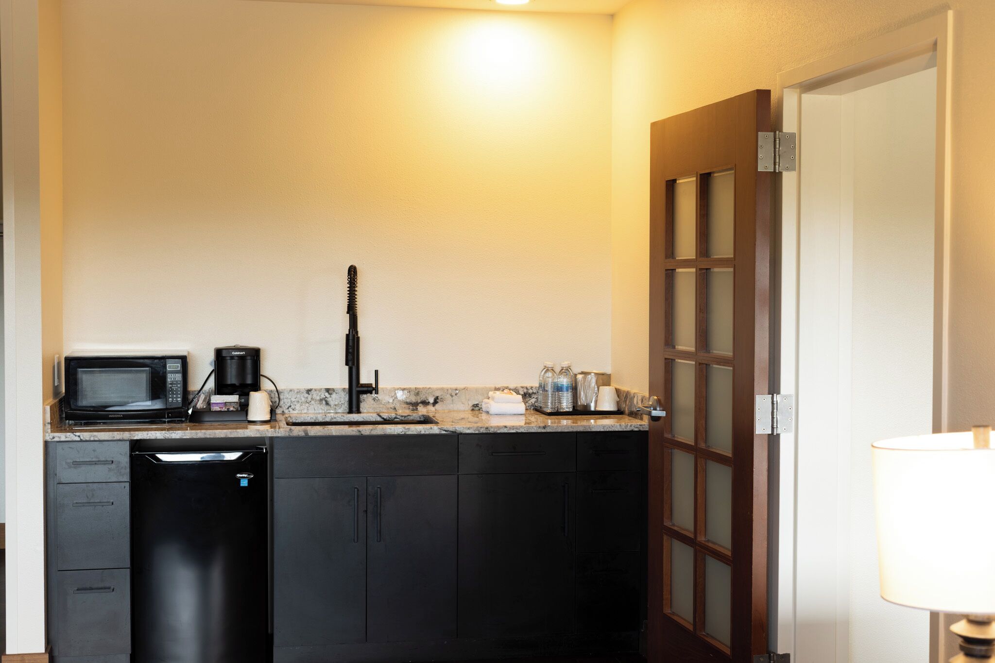 Una cocina compacta equipada con microondas, cafetera y lavavajillas.