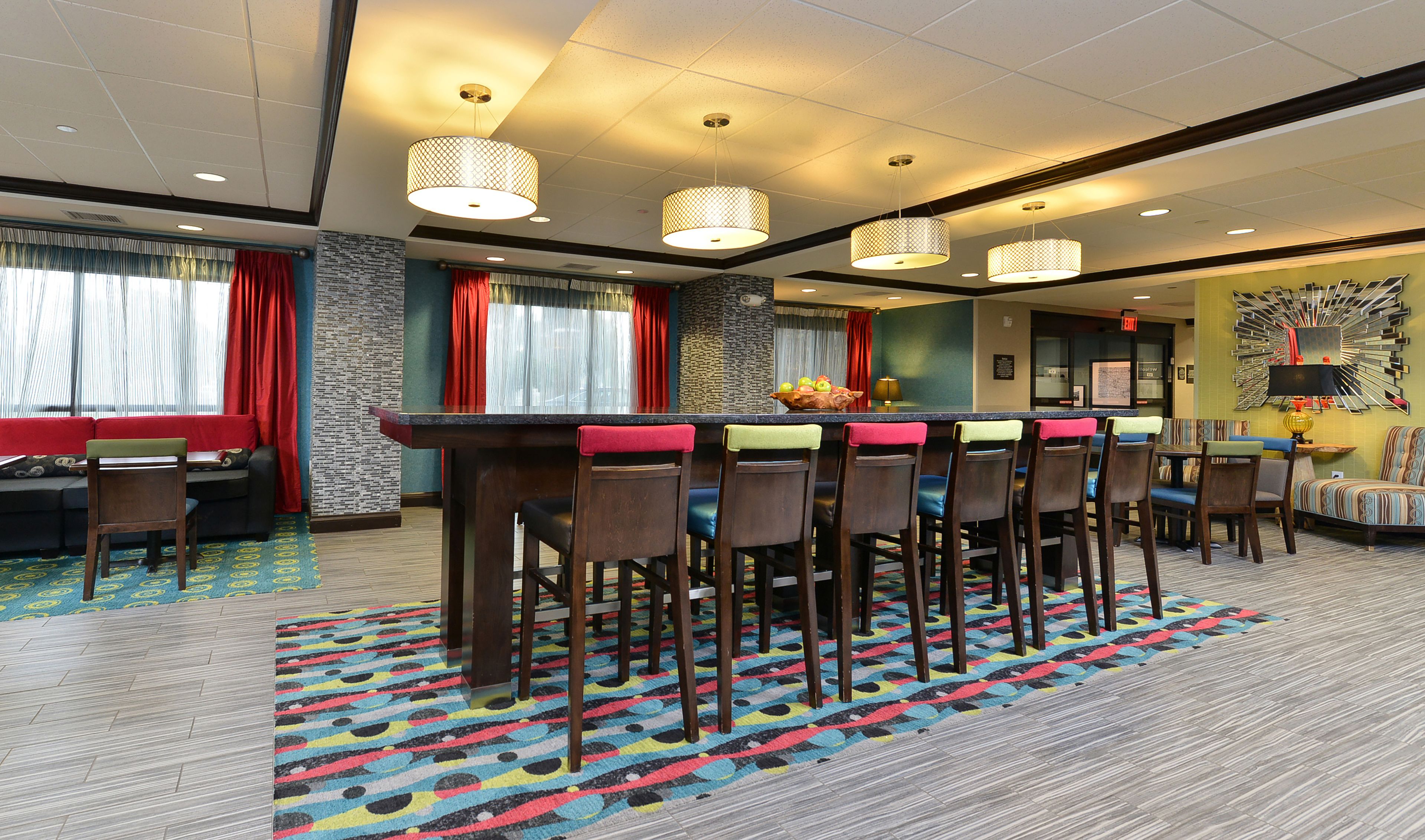 A hotel lobby with a bar area, seating, and a patterned carpet.