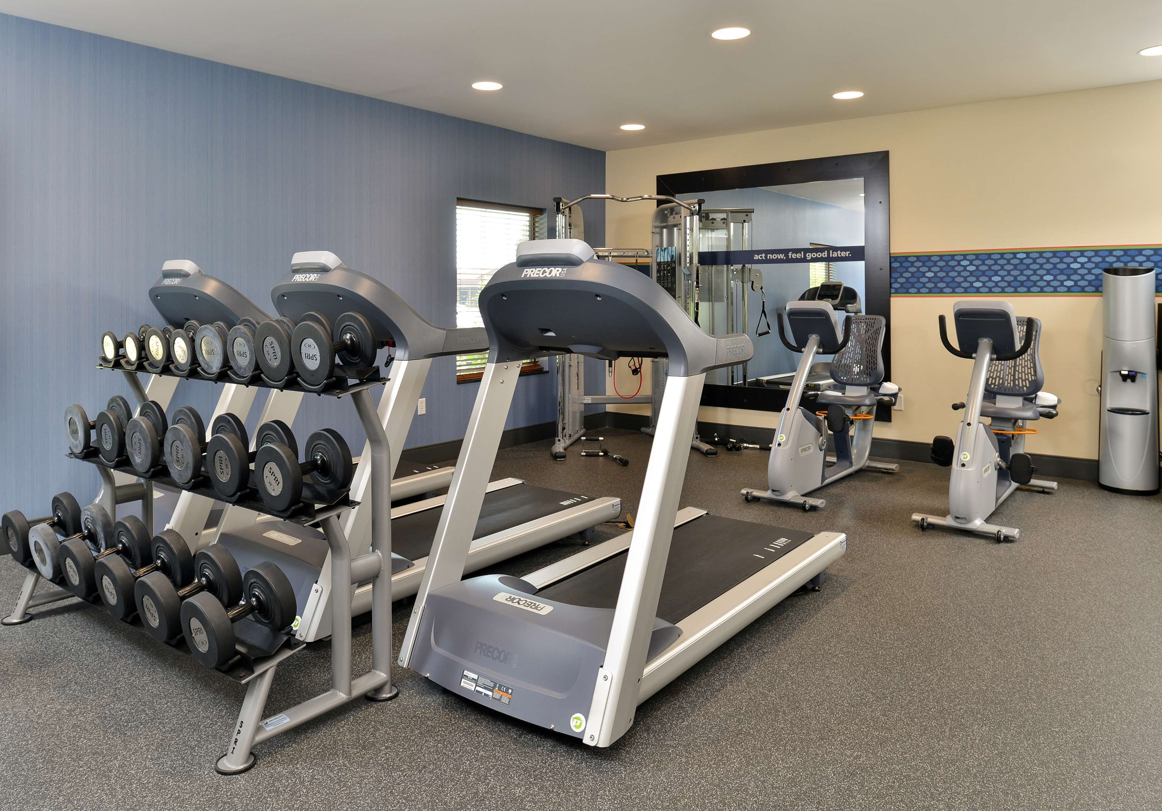 Une salle de sport équipée de tapis de course, d’haltères et d’appareils d’exercice.