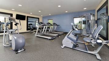 A gym with treadmills, elliptical machines, and weightlifting equipment.