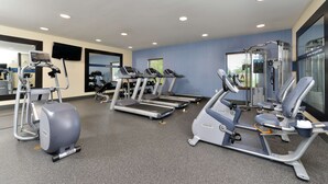 A gym with treadmills, elliptical machines, and weight equipment.