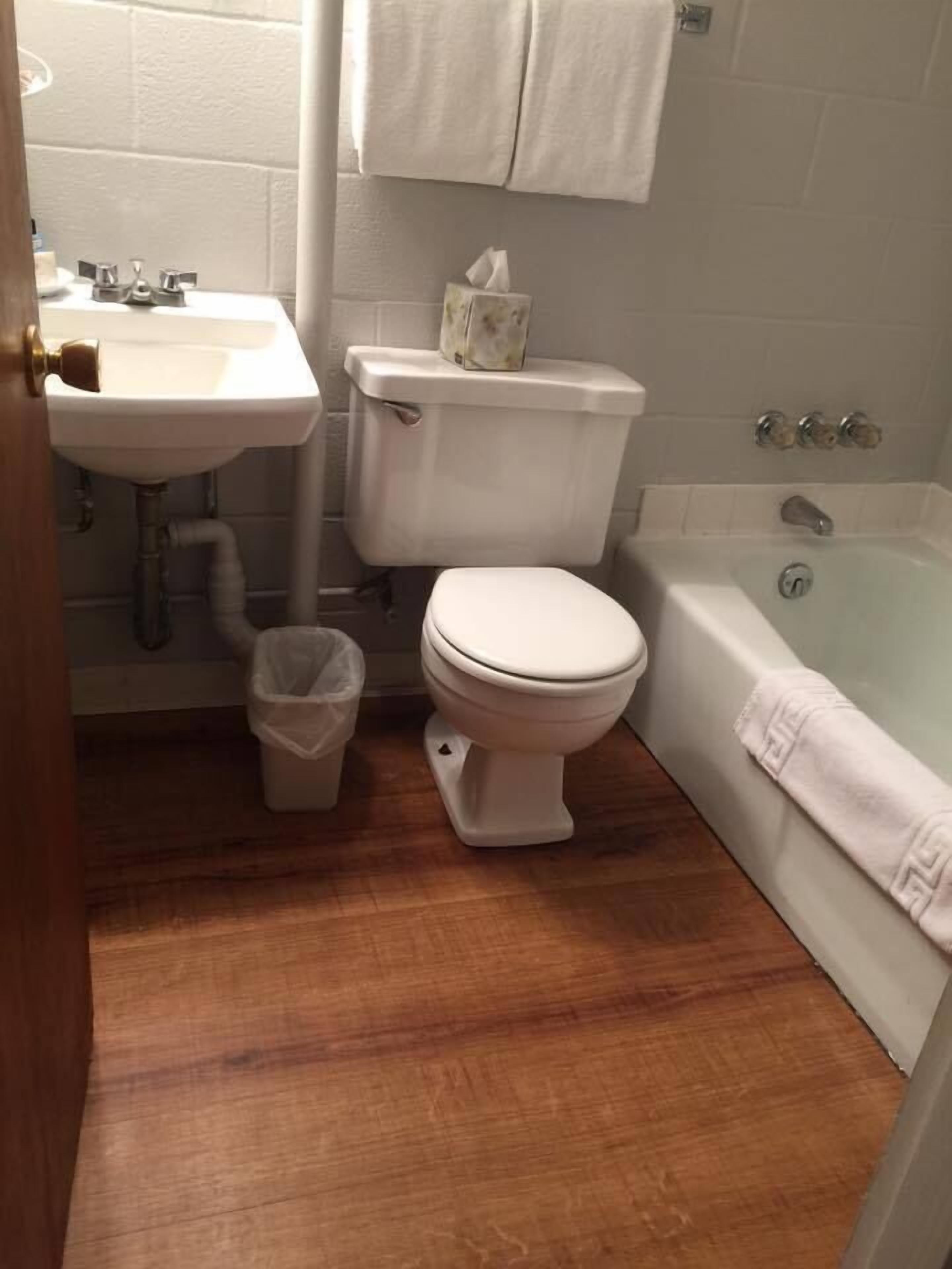 A bathroom with a white sink, toilet, and bathtub.