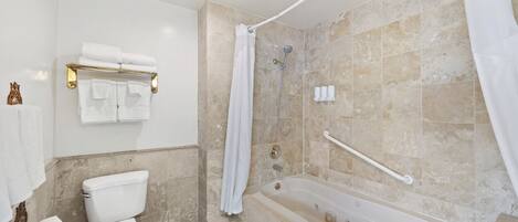 A bathroom with a toilet, bathtub, shower, and towel rack.