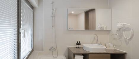 A modern bathroom with a bathtub, a sink, and a mirror.