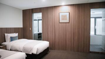 A hotel room with a large bed, a wardrobe, a mirror, and a door leading to a balcony.