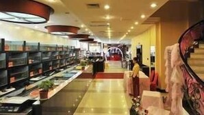 A spacious hotel lobby with a central staircase, a reception desk, and a long corridor with shelves on one side. - Super 8 Wuyi South Road - Fuzhou (Fuzhou)