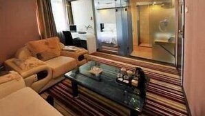 A modern hotel room with a sofa, a coffee table, and a large mirror. - Super 8 Wuyi South Road - Fuzhou (Fuzhou)